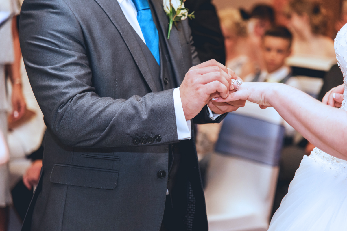 bride and groom placing ring on fingers
